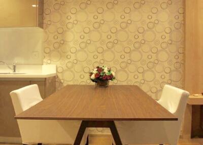 Dining area with wooden table and white chairs