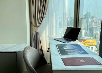 Modern office space with a desk, chair, and a large window offering city views