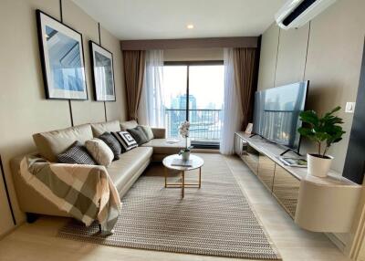 Modern living room with sofa, coffee table, TV, and window