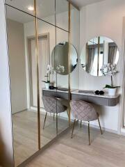 Modern bedroom vanity with a round mirror and upholstered chair