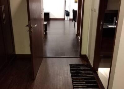 View through an open door into a room with a dark wooden floor