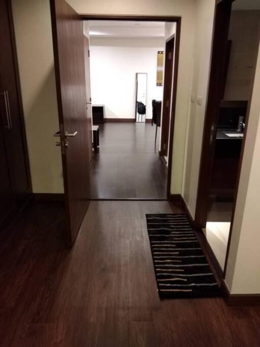 View through an open door into a room with a dark wooden floor