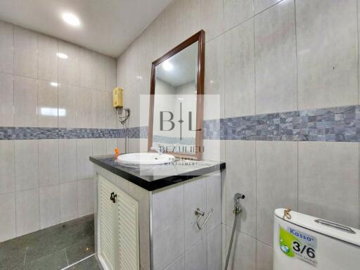 Modern bathroom with a vanity, mirror, and toilet