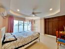 Spacious bedroom with large window, air conditioning, and ceiling fan