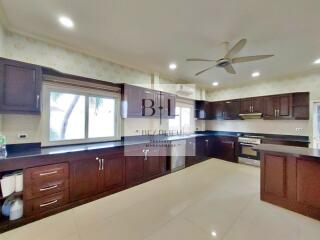 Spacious modern kitchen with wooden cabinets and large windows