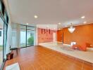 Spacious living room with large windows and orange accent wall