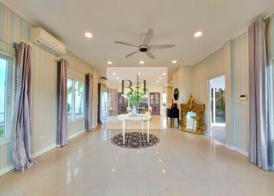 Spacious living room with polished floors, large windows, and stylish decor