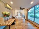 Living room with a large window, decorative plants, and a wall-mounted air conditioner