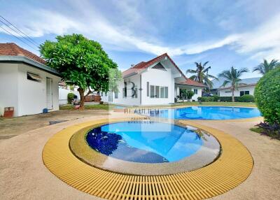 Beautiful exterior view of a property featuring a serene swimming pool and lush greenery.