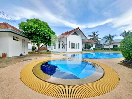 Beautiful exterior view of a property featuring a serene swimming pool and lush greenery.