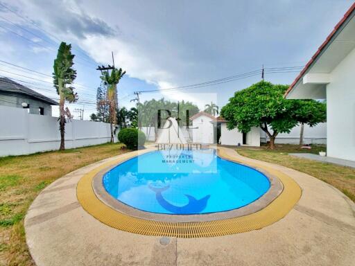 Outdoor swimming pool in a backyard with greenery and trees