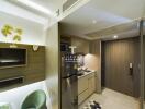 Modern compact kitchen with wooden cabinets, small dining area, and entrance door