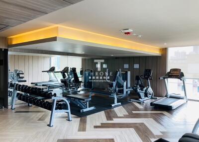modern gym with various exercise equipment including treadmills, elliptical machines, and free weights