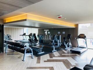 modern gym with various exercise equipment including treadmills, elliptical machines, and free weights