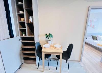 Compact dining area with built-in shelving and view into bedroom