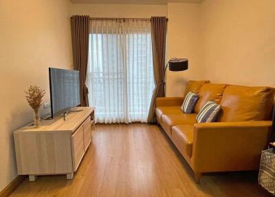 Cozy living room with brown leather sofa and TV