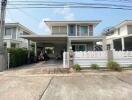 Two-story residential building with driveway and front yard