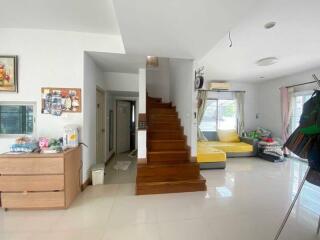 Spacious and well-lit living area with wooden staircase