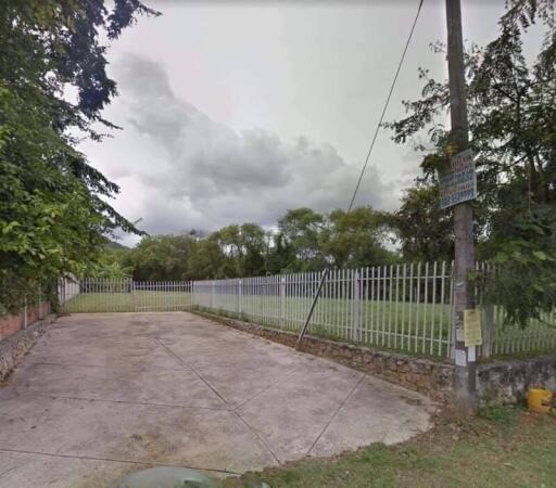 Outdoor space with fence and surrounding greenery