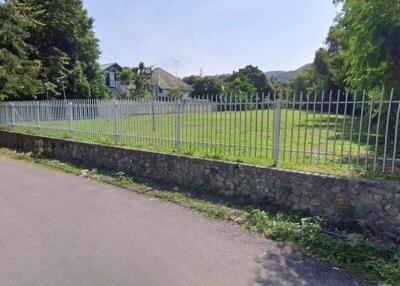 Photo of the property exterior showing a fenced yard with greenery and a nearby house