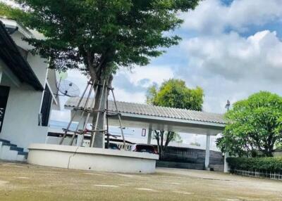 Spacious outdoor area with trees, parking, and a satellite dish