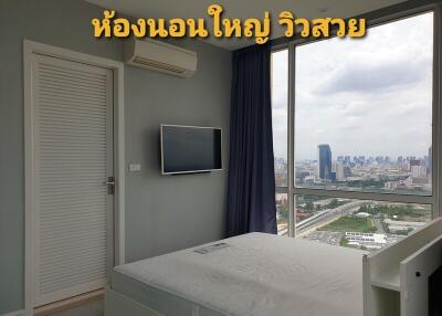 Bedroom with a large window offering a beautiful city view