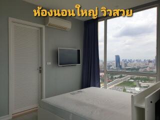 Bedroom with a large window offering a beautiful city view