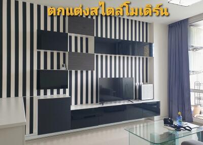 Modern living room with black and white striped wall design and a sleek media console