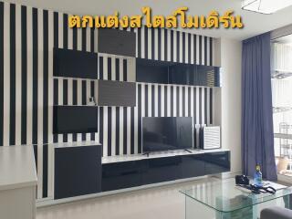 Modern living room with black and white striped wall design and a sleek media console