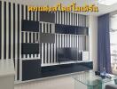 Modern living room with black and white striped wall design and a sleek media console