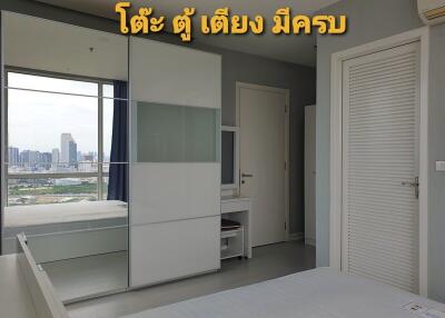 Modern bedroom with bed, wardrobe, and city view