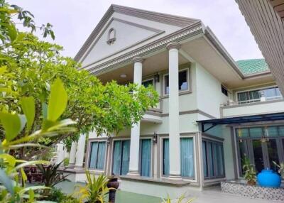 Front view of a multi-story house with a garden