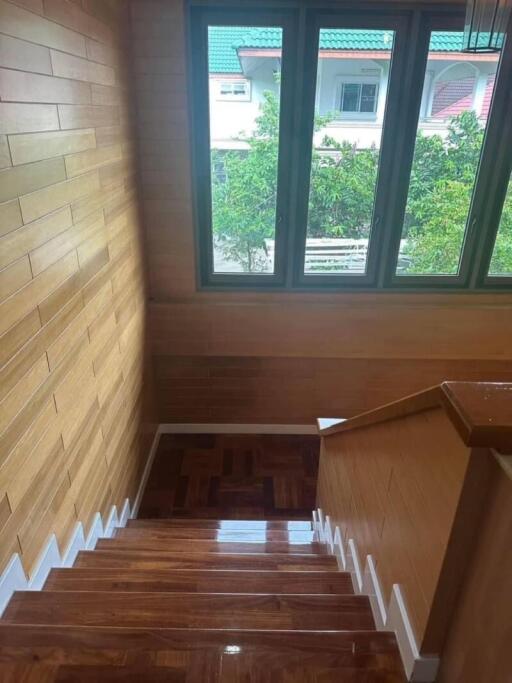 Indoor staircase with wooden steps and large windows