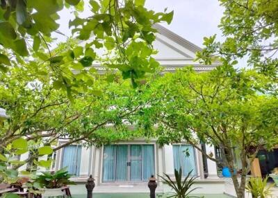 Front view of house with lush green garden