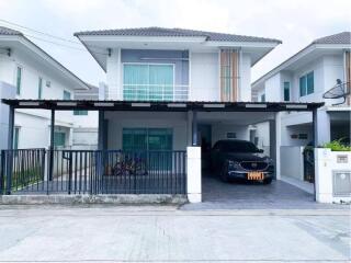 Modern two-story house with carport and fenced yard