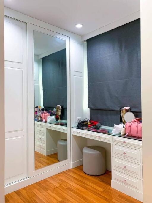 Vanity area with mirror and storage drawers in a bedroom