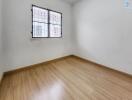 Minimalist empty bedroom with wooden flooring and window