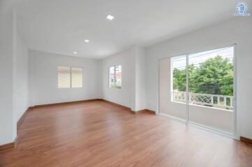 Spacious living room with wooden flooring and large windows