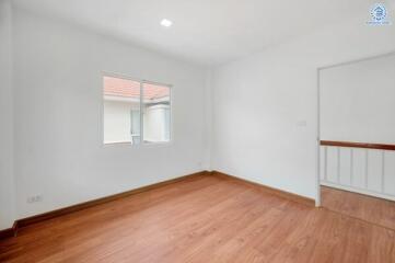 Empty bedroom with wooden floor and window