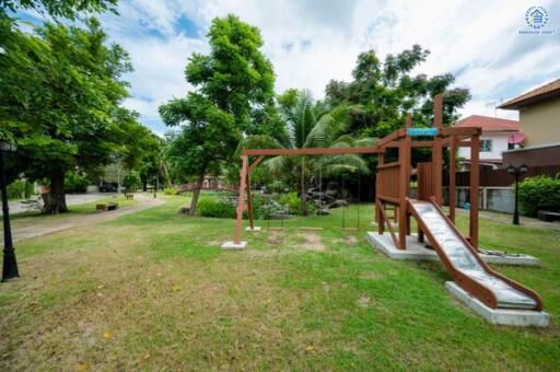 Outdoor playground area with slide and greenery