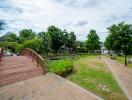 Community garden area with wooden bridge, pond, and walking paths