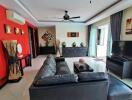 Modern living room with a black sofa, wall art, and large windows