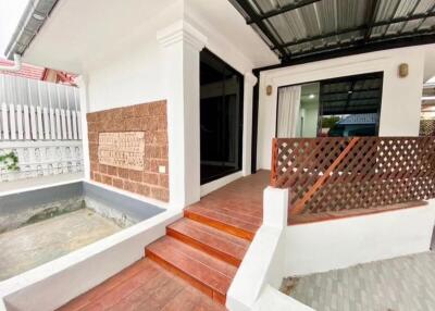 Front view of the building with a tiled entrance area and steps leading to the front door.