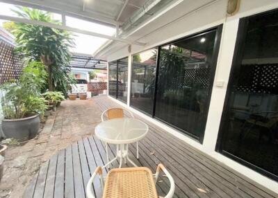 Covered patio area with glass doors and outdoor furniture