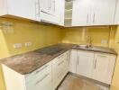 Modern kitchen with white cabinetry and marble countertops