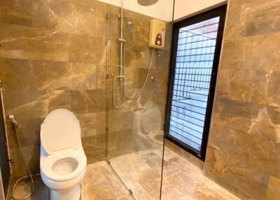 Modern bathroom with glass shower and brown tile design