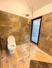 Modern bathroom with glass shower and brown tile design