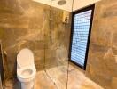 Modern bathroom with glass shower and brown tile design