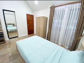 Modern bedroom with large window and blue bedspread