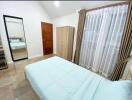 Modern bedroom with large window and blue bedspread